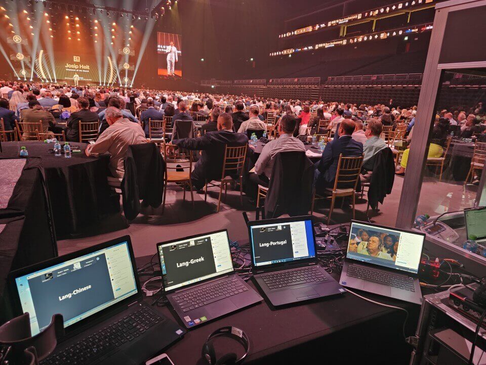 hybrid meeting. hybrid event with laptops showing the languages that are being ointerpreted in a big venue the coca cola arena in Dubai